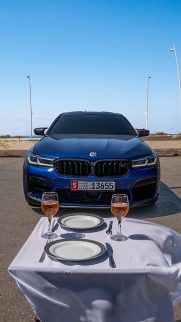 Blue BMW M5 Competition by the sea
