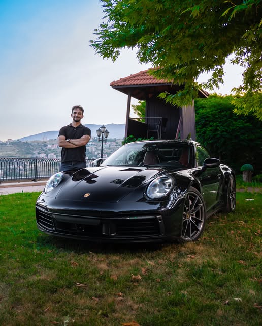 Wafik Masry standing beside a black Porsche 911